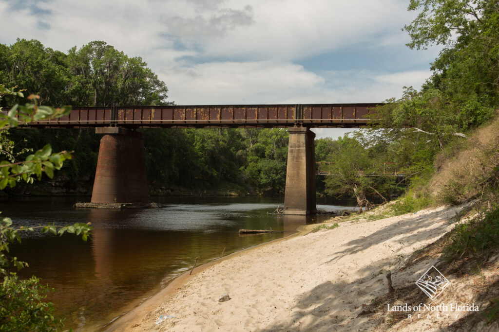 Present day train trestle bridge at Ellaville over the Suwannee River, with some white sand beach on the banks